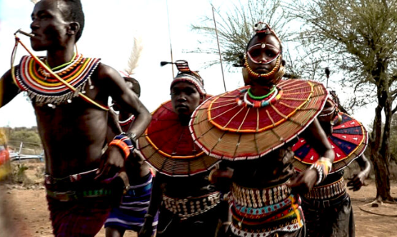 “Pokot people in Uganda wearing traditional attire and engaging in cultural activities.”